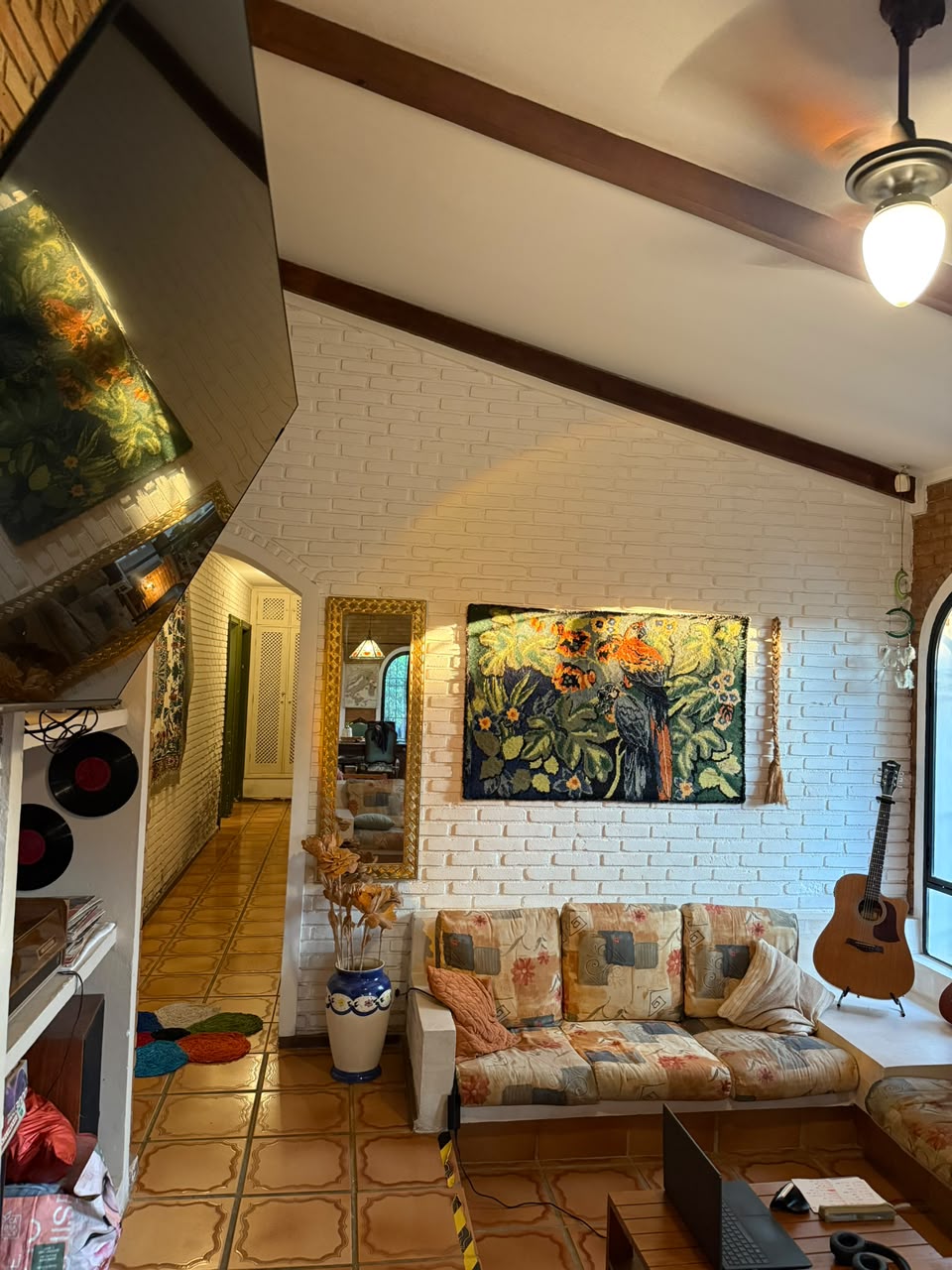 Sala de estar aconchegante da Golden Garden House com sofá e violão