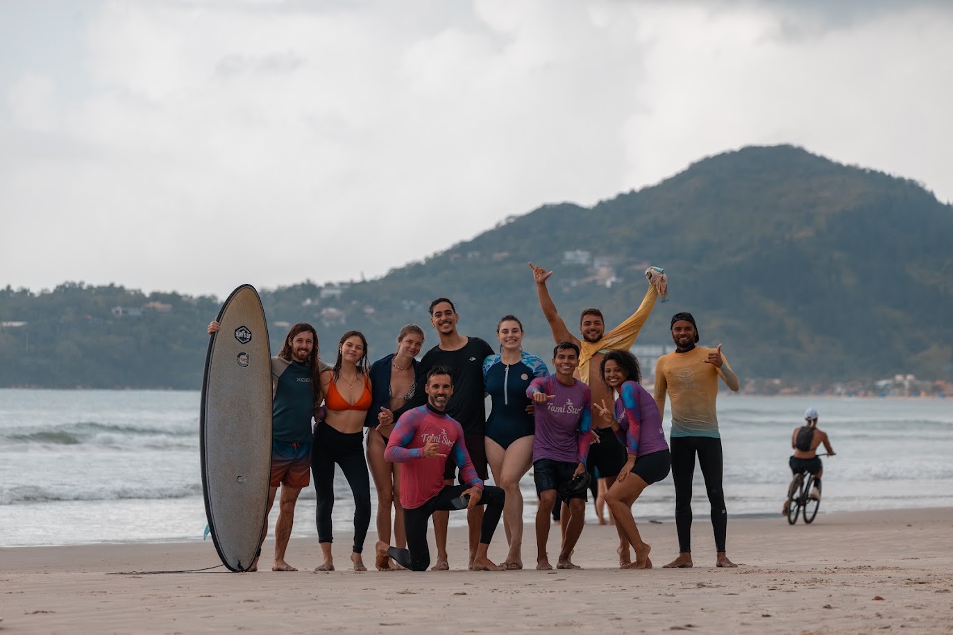 Galera da Surf Trip reunida na praia com a prancha para a aula de surf